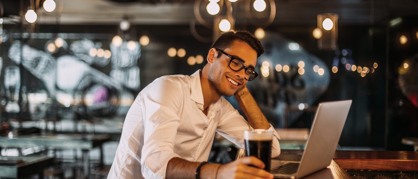 Portrait of a stylish man working on a computer in a restaurant.